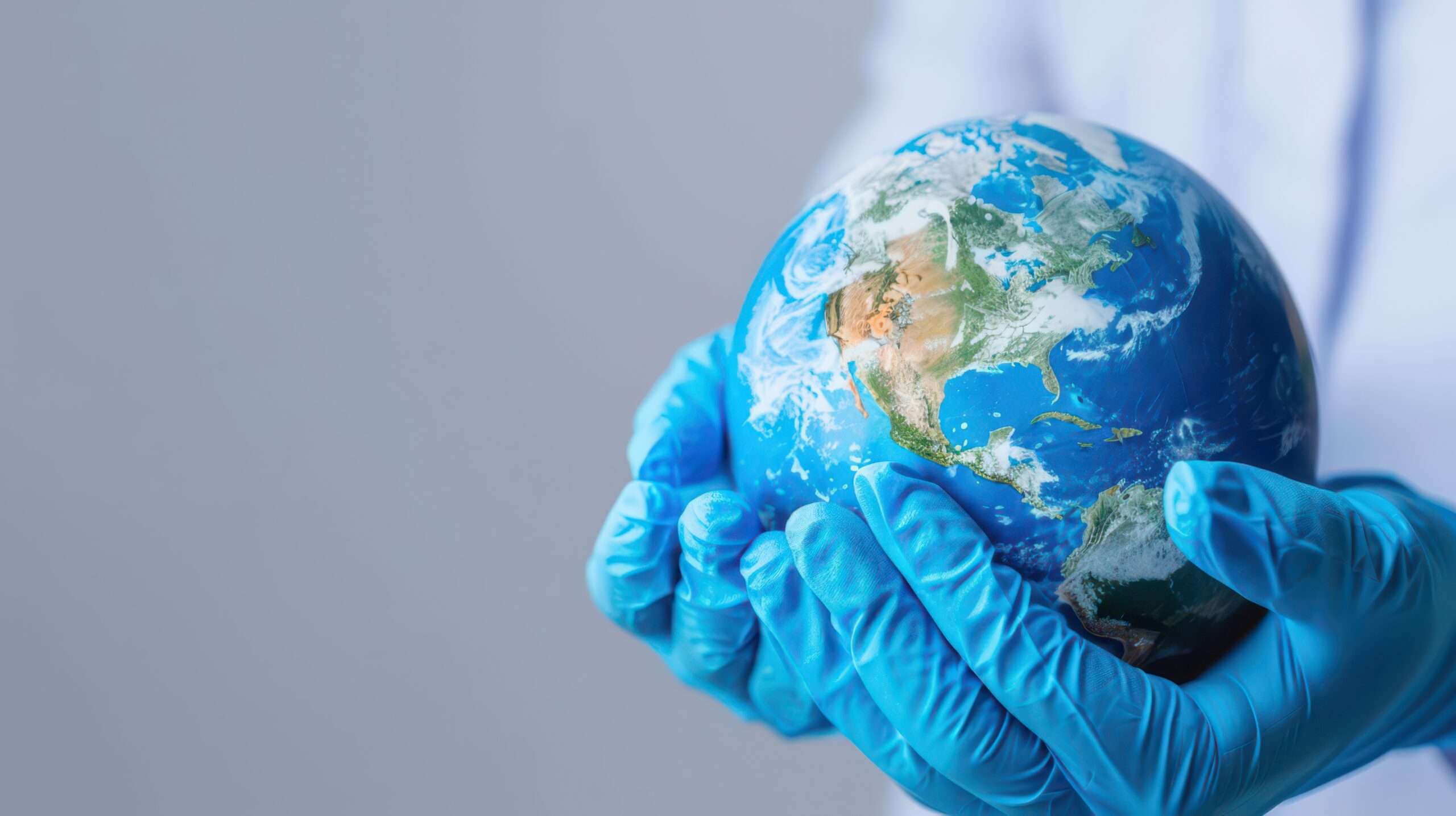 Gloves with an earth globe on a grey background depicting a health sciences distance learning programme from NWU